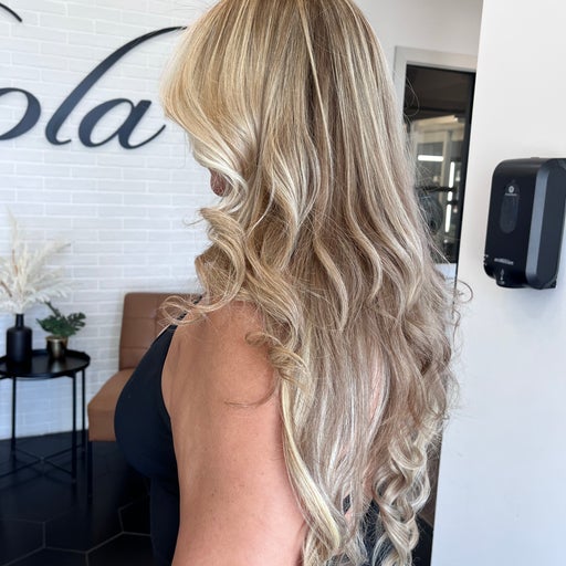 Long blonde balayage with soft curls styled at Adry's Salon & Spa