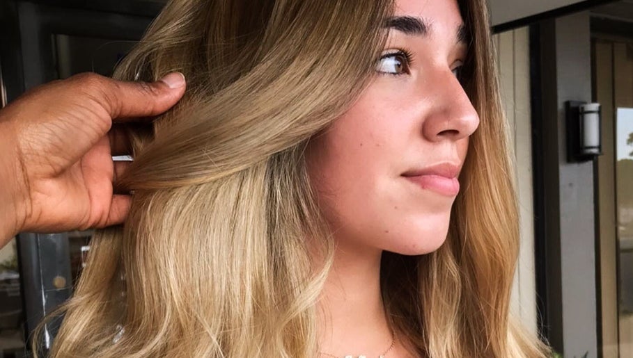A stylist finishing a soft, sun-kissed blowout at Adry's Salon & Spa, Davie